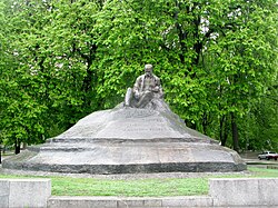 A monument depicting a man sitting on a rock