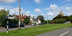 The green at Hawkley, Hampshire, England, with the tower of St. Peter and Paul church. August 2021.